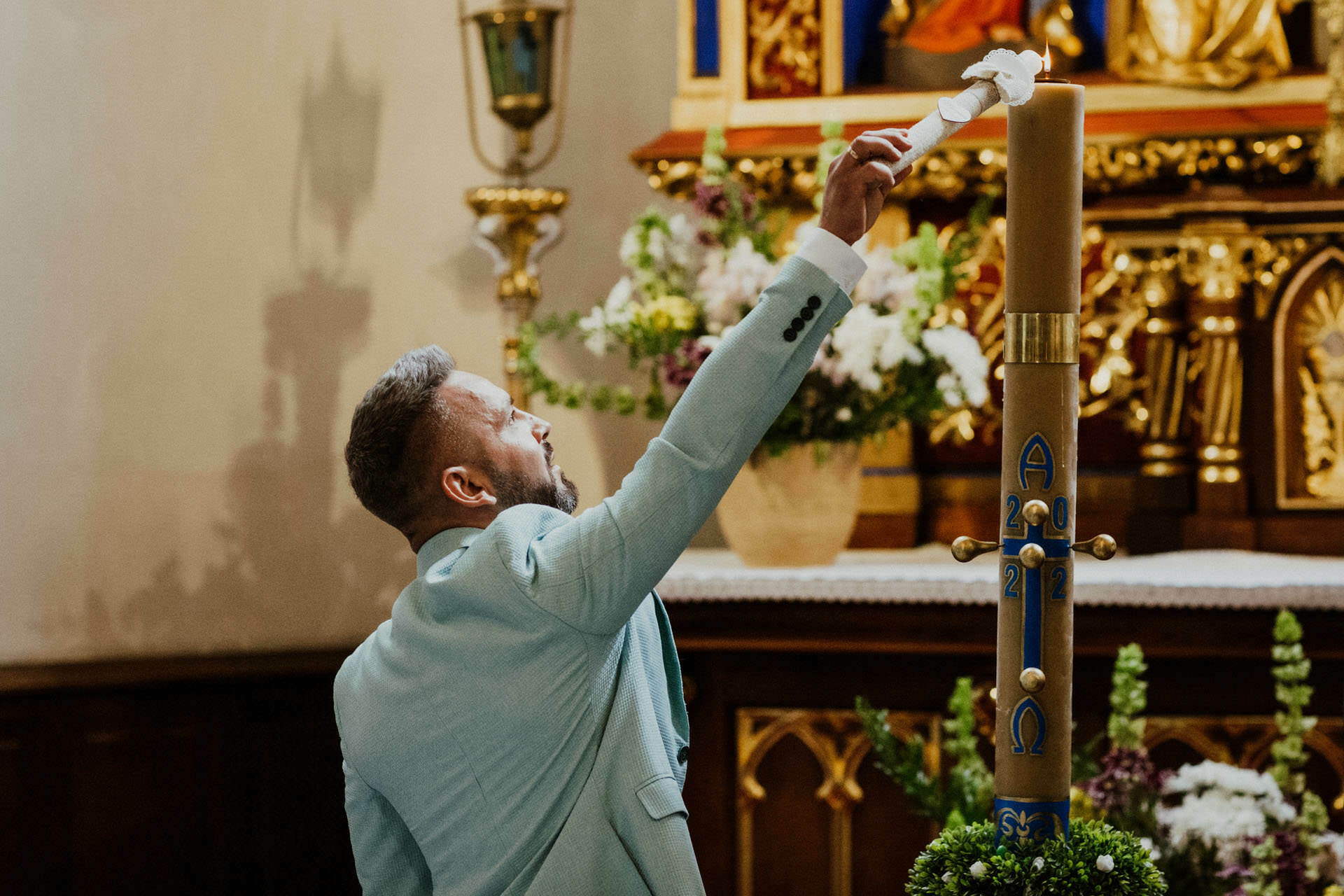 ojciec chrzestny zapala świecę od paschału Kraków