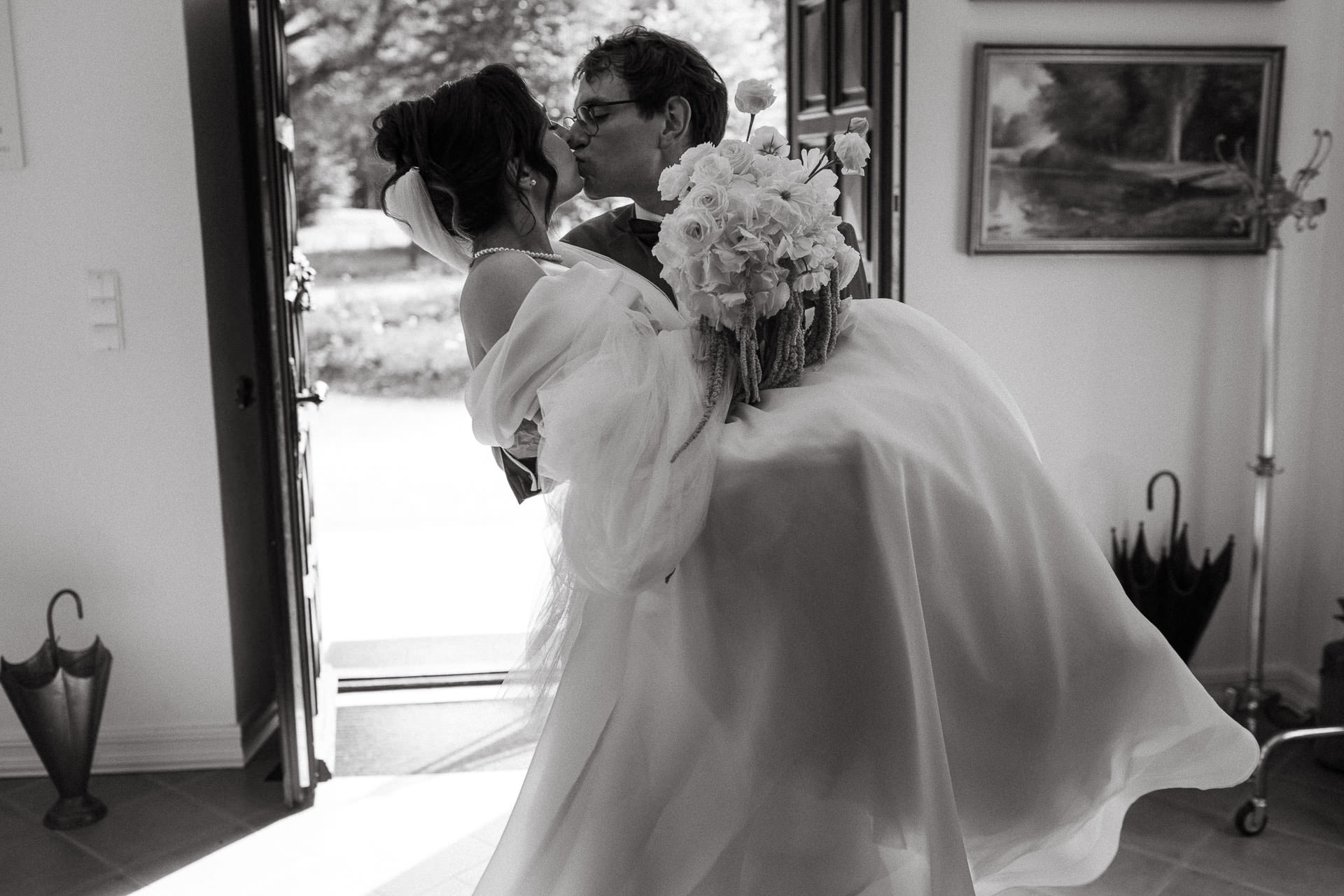 Pan Młody wnosi na rękach Pannę Młodą